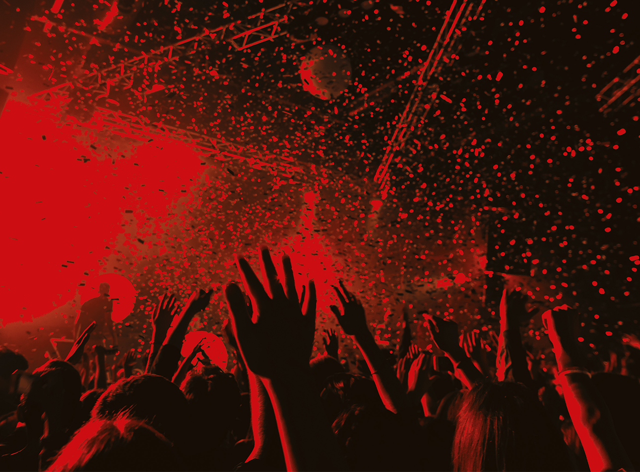 A red and black washed photo of a festival. Hands and confetti are visible.