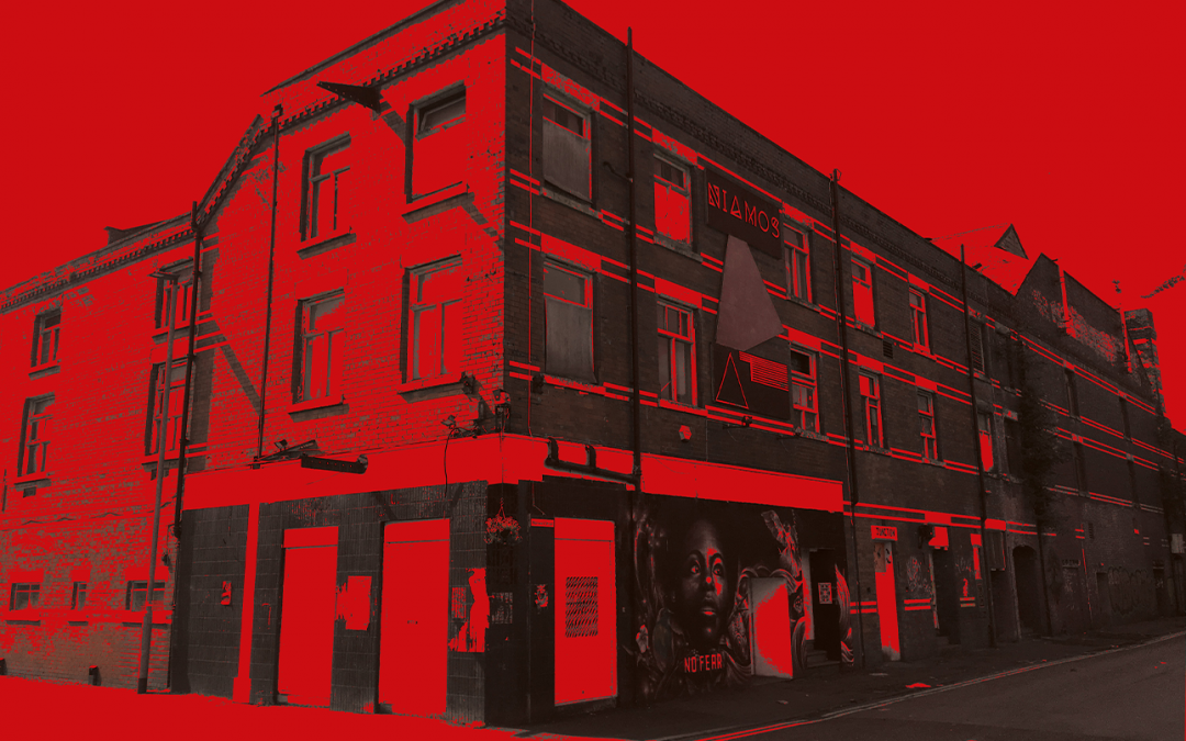 Red washed image of a street corner in Manchester.