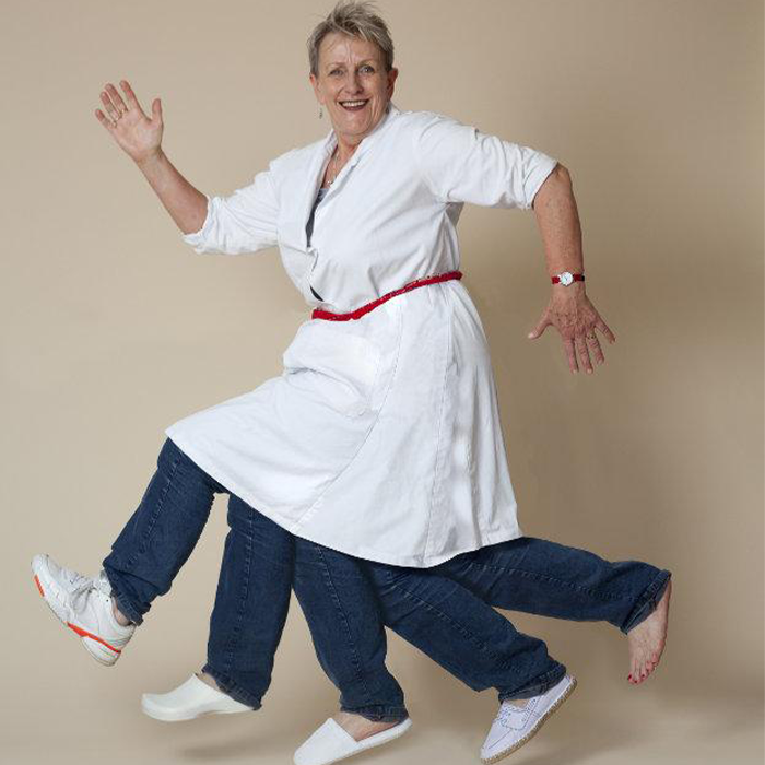 A woman in a white dress and blue jeans appears to have 5 legs in a running motion