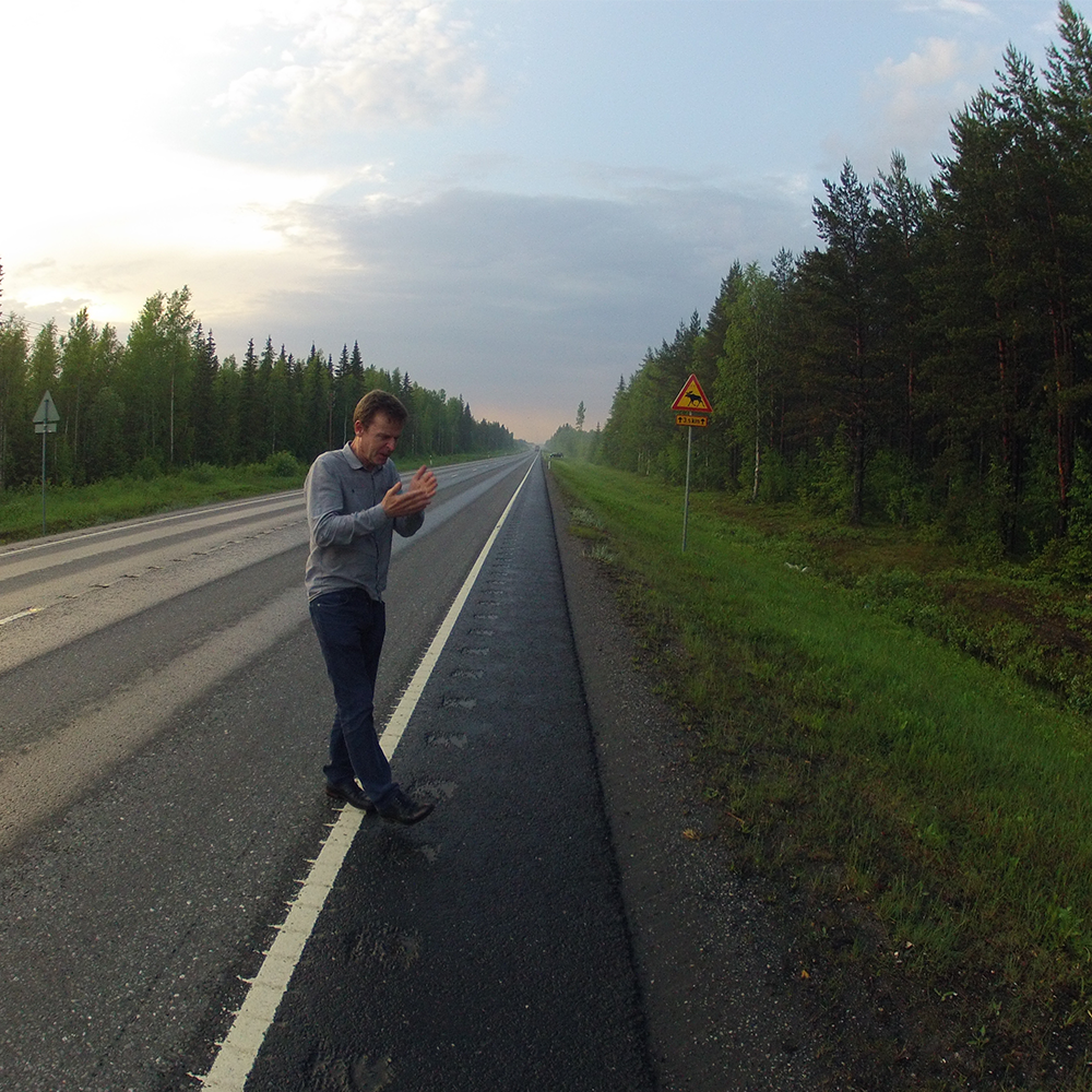 A man in jumper and jeans stood in the road