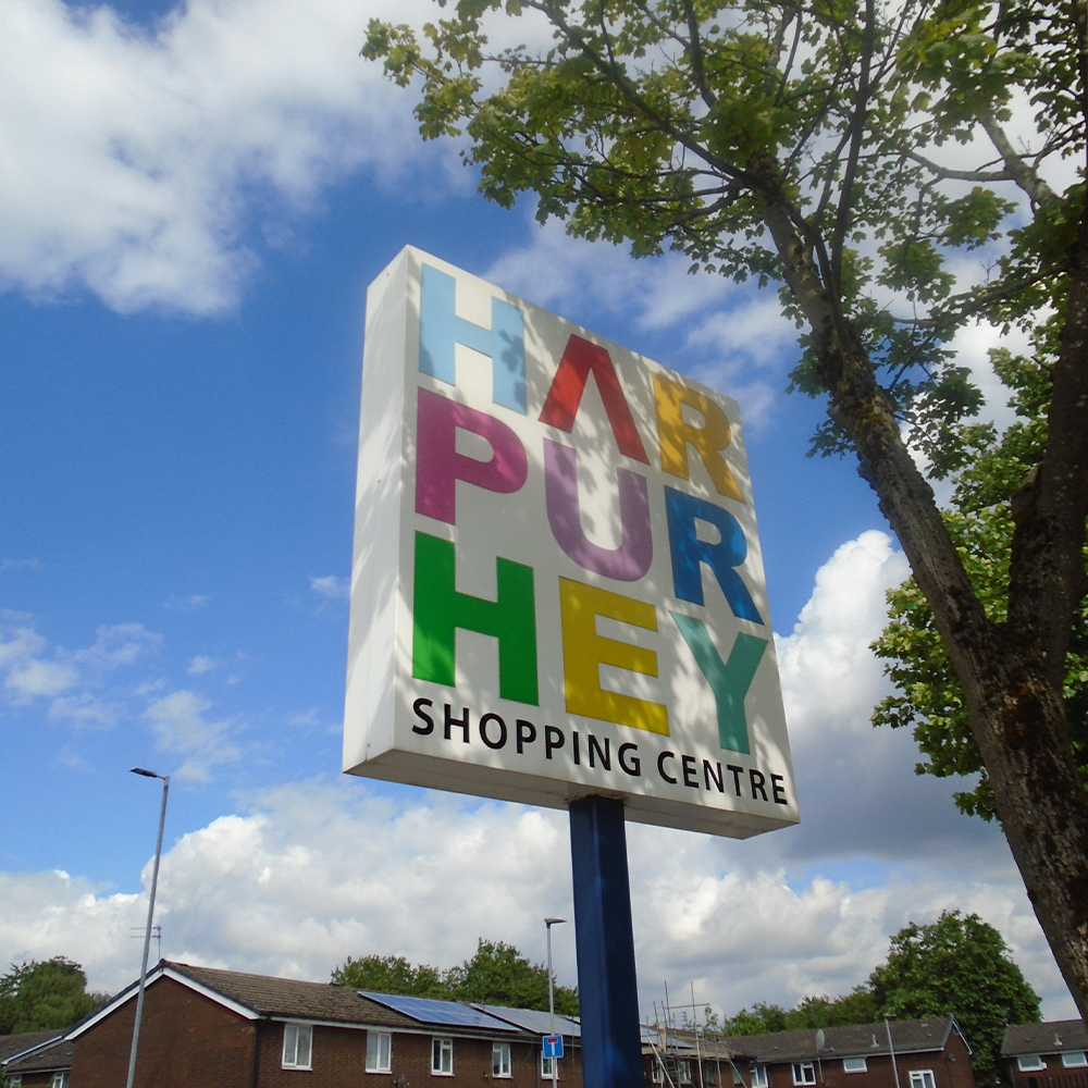 A sign reads 'Harpurhey Shopping Centre'