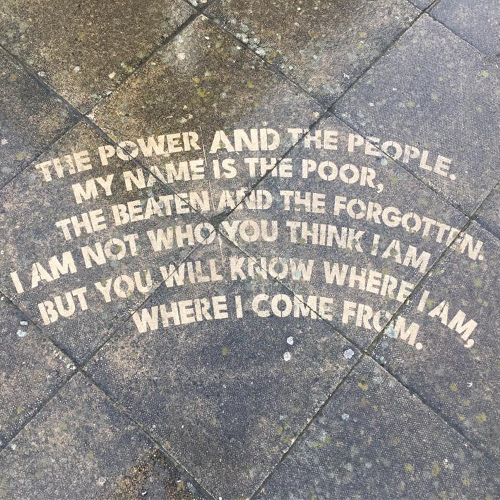 A poem is powerwashed into the pavement in Central Manchester 